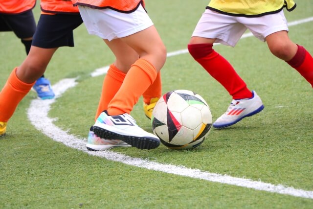 チームでサッカーをする子供たち